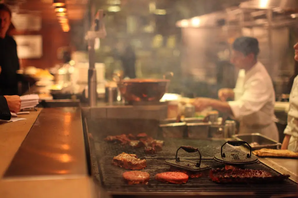 Köche arbeiten am Grill in einer vollen Restaurantküche