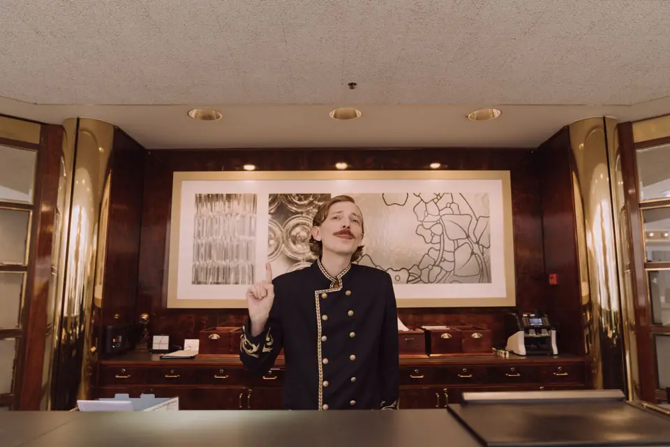 Rezeptionist in Uniform am Tresen eines Hotels